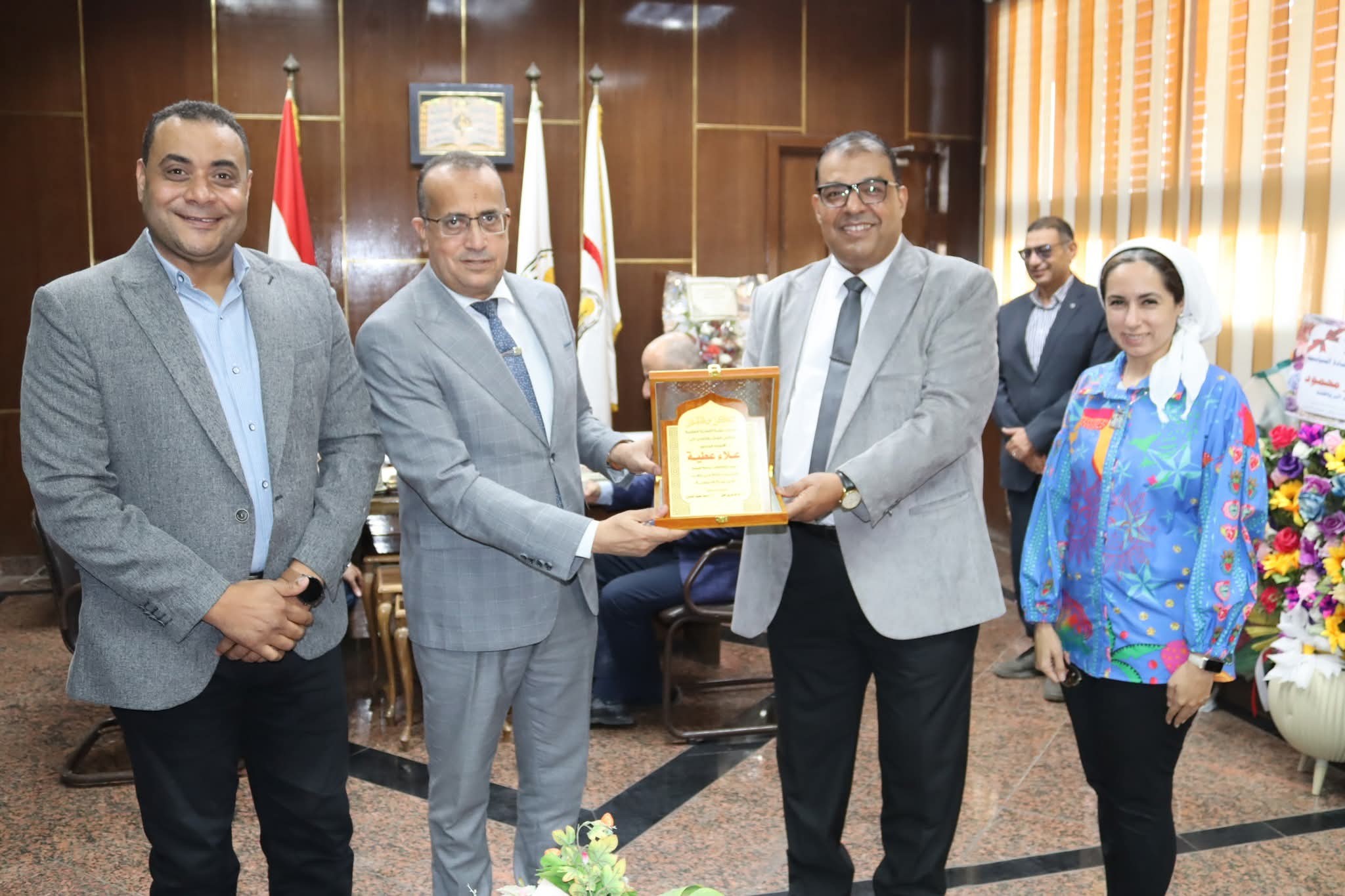 Presenting the graduation shield of the third batch of the professional diploma in therapeutic nutrition to Professor Dr. Alaa Attia, Dean of the Faculty of Medicine and Chairman of the Board of Directors of University Hospitals.